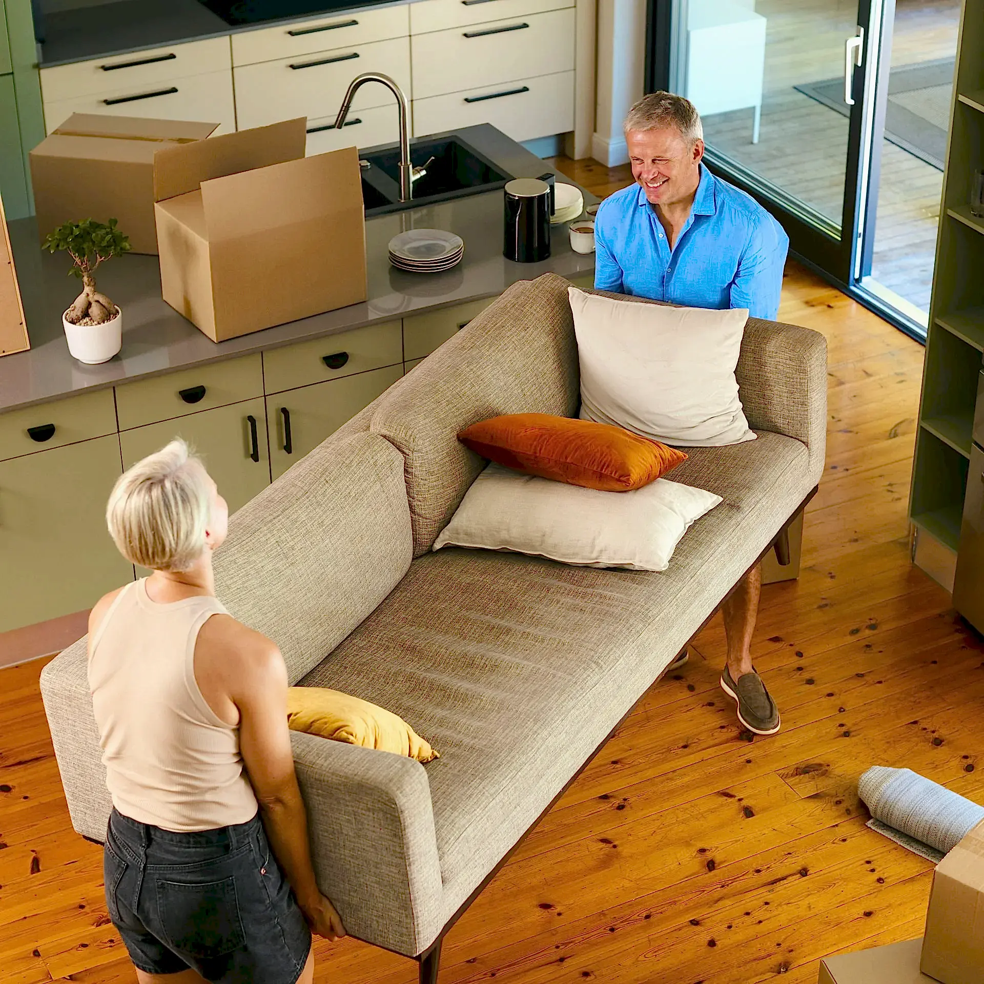 overhead-shot-of-mature-couple-carrying-sofa-movin-2024-03-05-23-04-56-utc